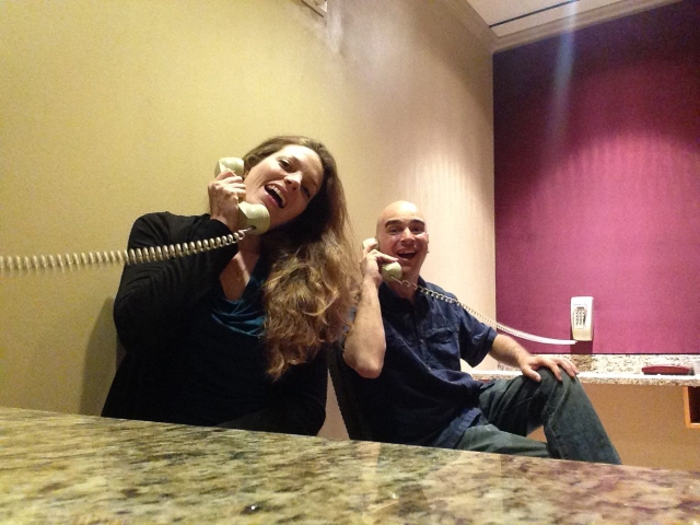 A woman and man smiling and answering a telephone to convey the idea of positive customer service.