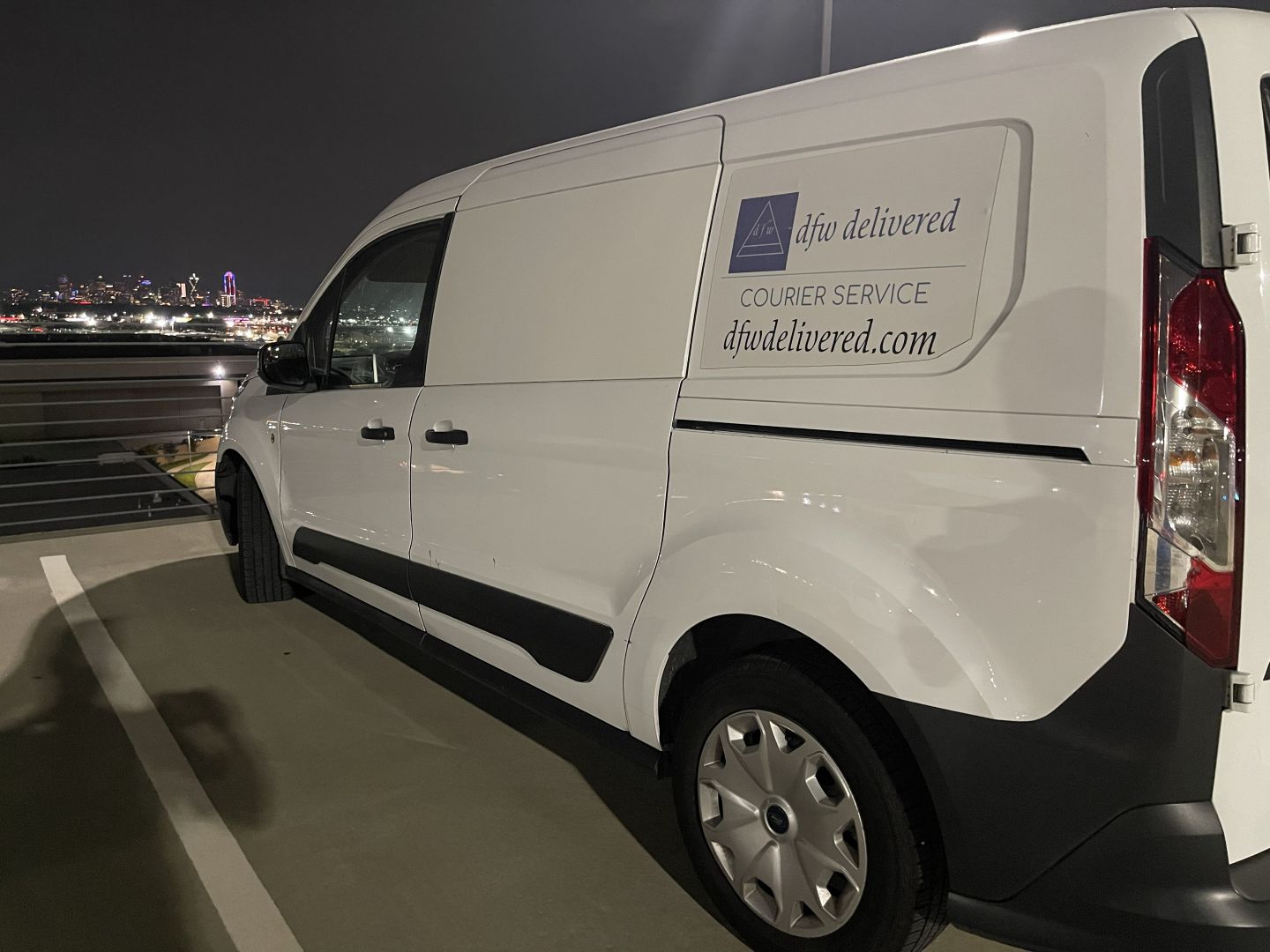 Delivery van at Love Field overlooking downtown Dallas